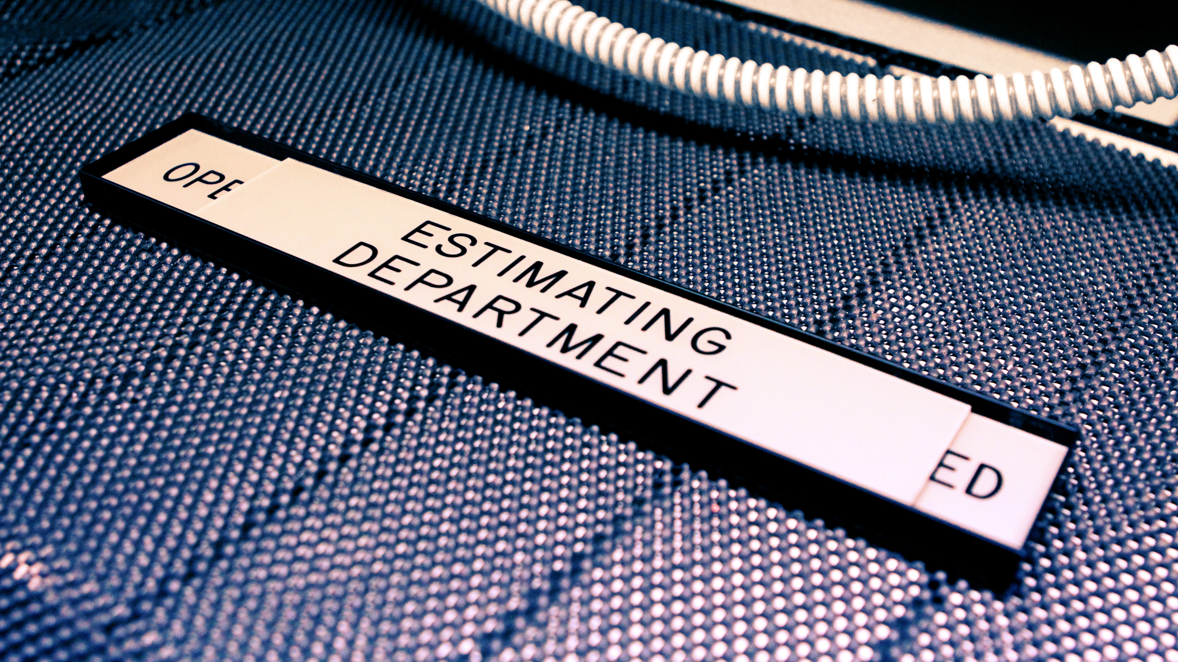 Engraved Estimating Department label on blue cable conduit