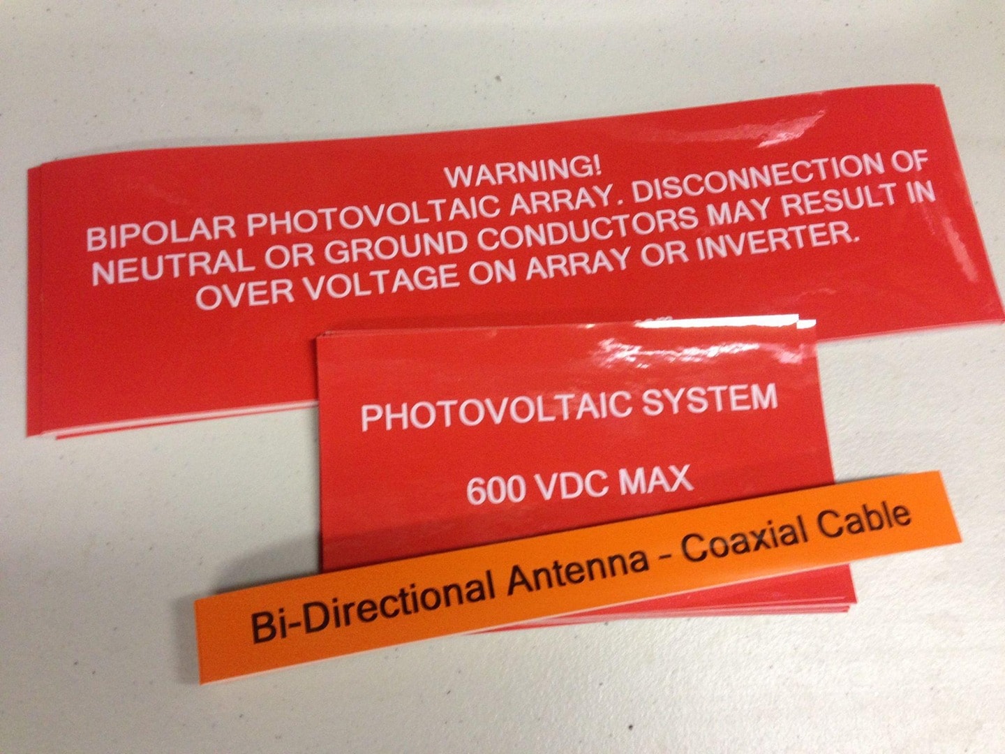 Red vinyl labels — Bipolar Photovoltaic Array warning, Photovoltaic System 600 VDC Max, and Bi-Directional Antenna Coaxial Cable