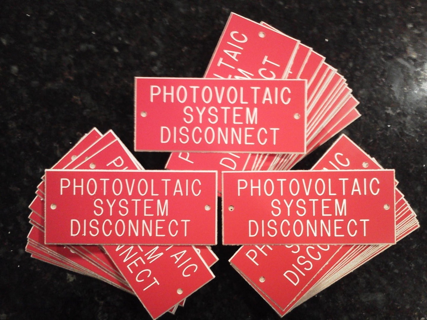 Large batch of engraved red phenolic Photovoltaic System Disconnect labels