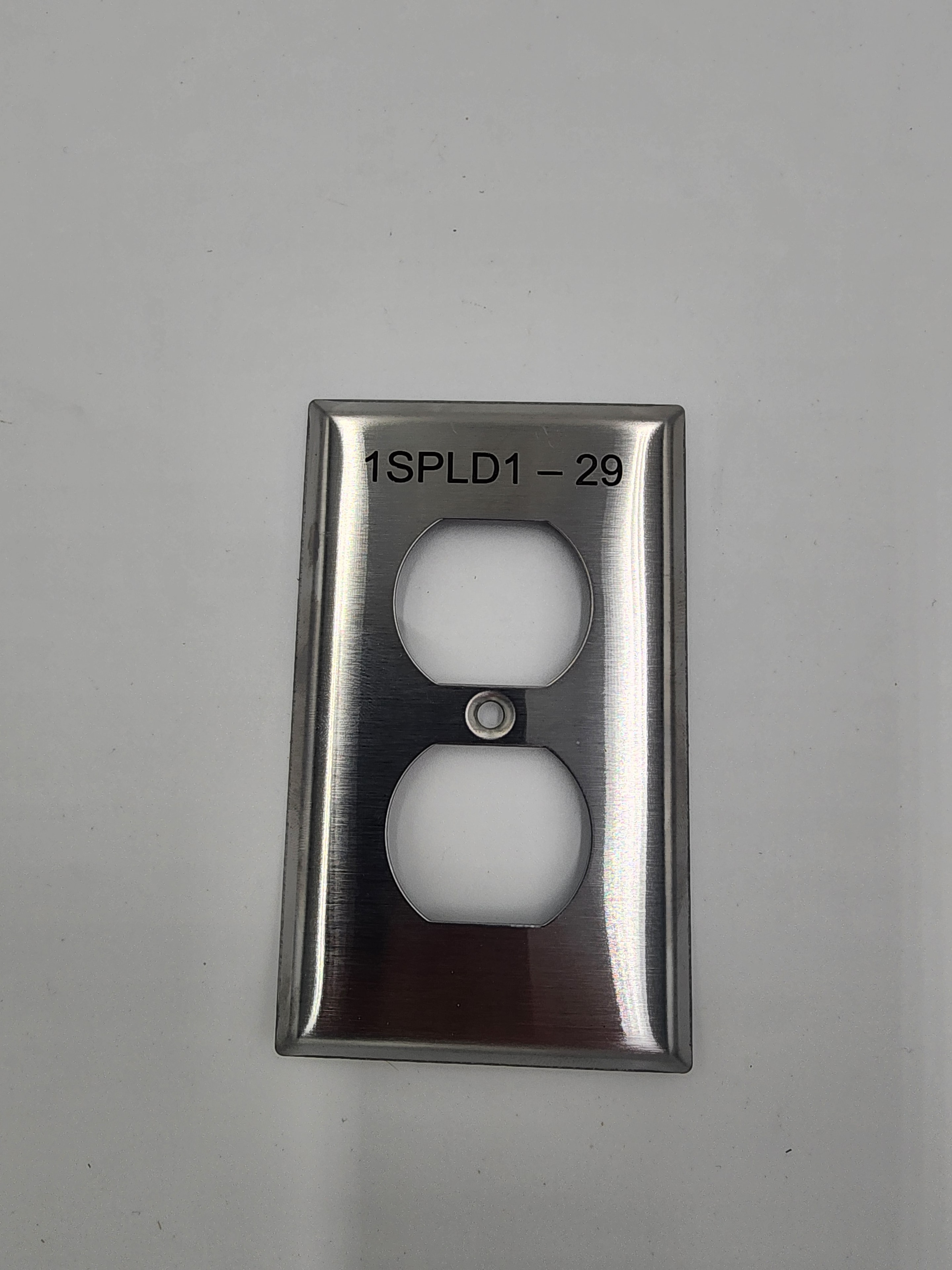 Engraved stainless steel duplex outlet plate labeled 1SPLD1-29