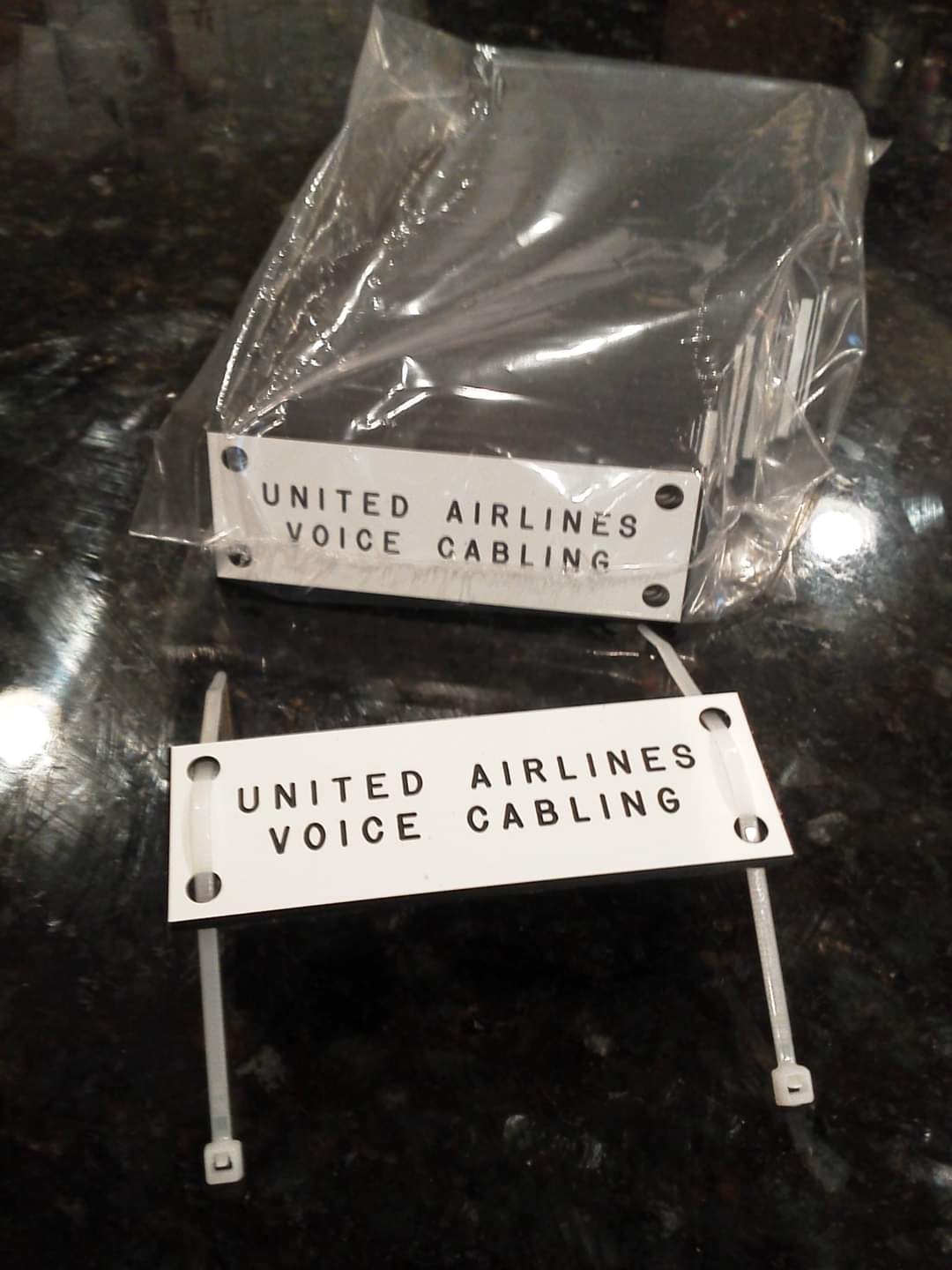 Engraved stainless steel United Airlines Voice Cabling tags with zip-tie mounts